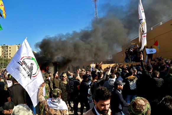Protesters burn property in front of the U.S. embassy compound, in Baghdad, Iraq, Tuesday, Dec. 31, 2019. Dozens of angry Iraqi Shiite militia supporters broke into the U.S. Embassy compound in Baghda ...