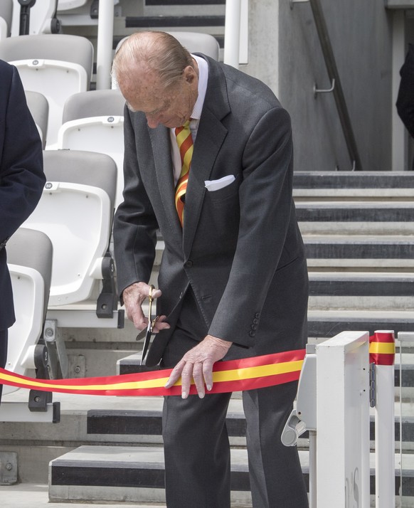 FILE - In this Wednesday, May 3, 2017 file photo Britain&#039;s Prince Philip, the Duke of Edinburgh, cuts a ribbon during his visit to Lord&#039;s Cricket Ground to open the new Warner Stand, in Lond ...