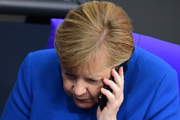 epa07926720 German Chancellor Angela Merkel talks on the phone after her speech to the German Bundestag in Berlin, Germany, 17 October 2019. Merkel delivered a government declaration to the members of ...