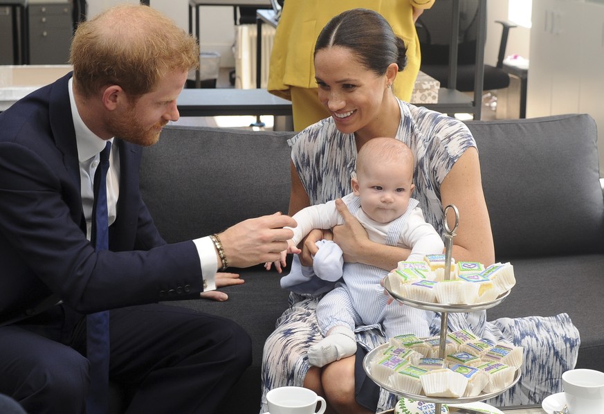 epa07868473 Britain&#039;s Prince Harry, The Duke of Sussex (L) and his wife Meghan, Duchess of Sussex (R) holding her son Archie, have tea with Archbishop Desmond Tutu (not pictured) and his daughter ...