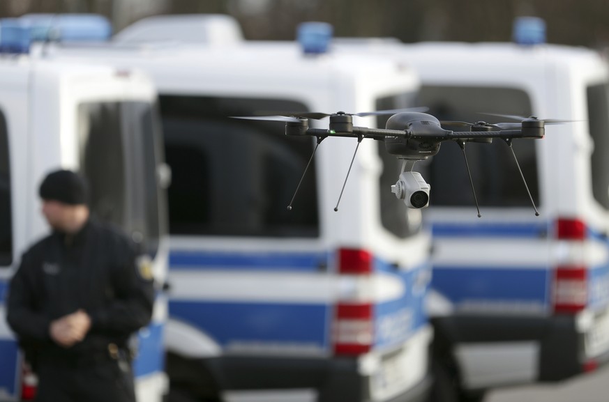 A drone lands netxt to police cars during a ceremony to handover 50 police vehicles and other equipment to the federal police by the German interior ministry in Potsdam, Germany, Thursday, Dec. 14, 20 ...