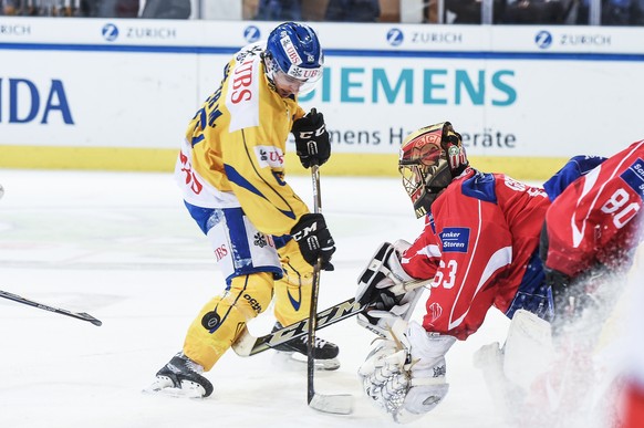 Davos`Marc Wieser fights for the puck with Suisse player Leonardo Genoni during the game between Team Suisse and HC Davos at the 91th Spengler Cup ice hockey tournament in Davos, Switzerland, Saturday ...