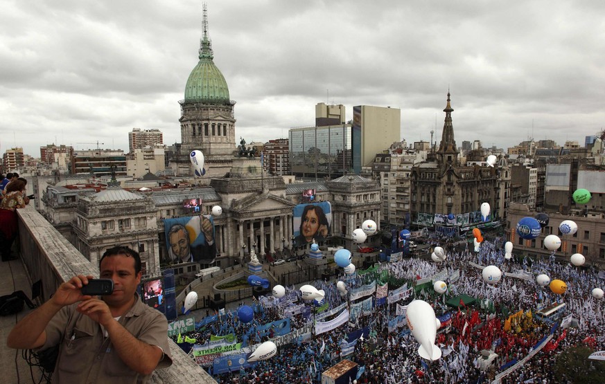 Ein Mann macht ein Foto von sich selber und den vielen Menschen, die an der Pro-Kirchner-Demo teilnehmen.