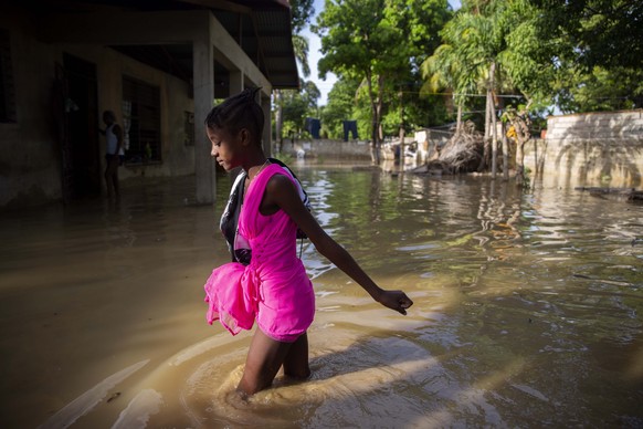 A girl wades towards her flooded home a day after the passing of Tropical Storm Laura in Port-au-Prince, Haiti, Monday, Aug. 24, 2020. Laura battered the Dominican Republic and Haiti on it&#039;s way  ...