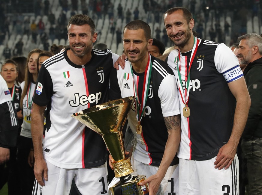Juventus&#039; Andrea Barzagli, Juventus&#039; Leonardo Bonucci, and Juventus&#039; Giorgio Chiellini, from left to right, pose after winning the Serie A soccer title trophy, at the Allianz Stadium, i ...