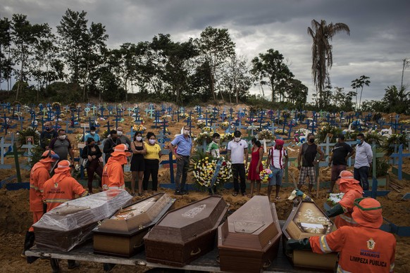 epa08380977 People attend a funeral at a mass grave at the Nossa Senhora Aparecida cemetery in Manaus, Brazil, 23 April 2020. The new section of the cemetery was opened amid a sharp rise in COVID-19 v ...