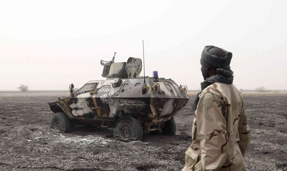 A Chadian soldier walks past an armored vehicle that the Chadian military said belonged to insurgent group Boko Haram that they destroyed in battle in Gambaru, Nigeria, February 26, 2015. The Chadian  ...