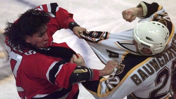 New Jersey Devils&#039; Scott Daniels, left, grapples with Boston Bruins Ken Baumgartner (22) in the first period of their NHL game in Boston Monday night, Jan. 12, 1998.(AP Photo/Elise Amendola)