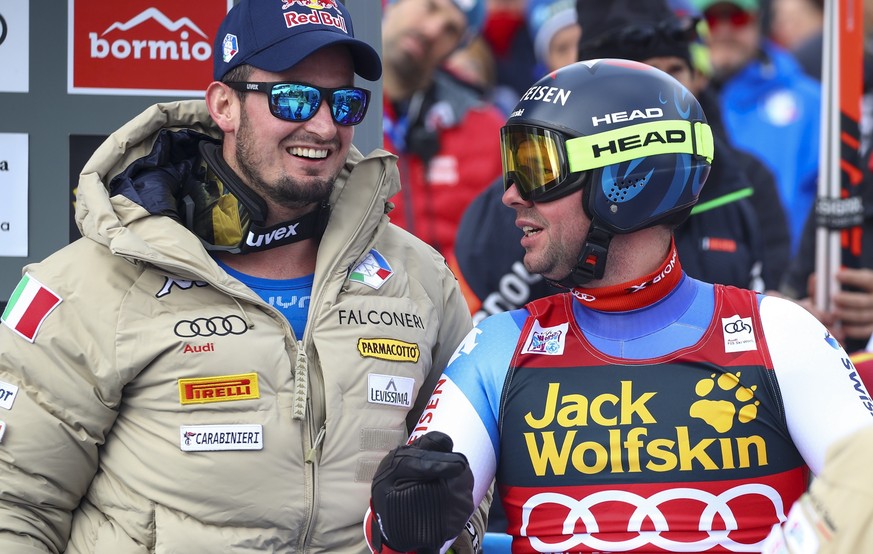 Italy&#039;s Dominik Paris, left, shares a word with Switzerland&#039;s Beat Feuz at the finish area of an alpine ski, men&#039;s World Cup downhill, in Bormio, Italy, Friday, Dec. 27, 2019. (AP Photo ...