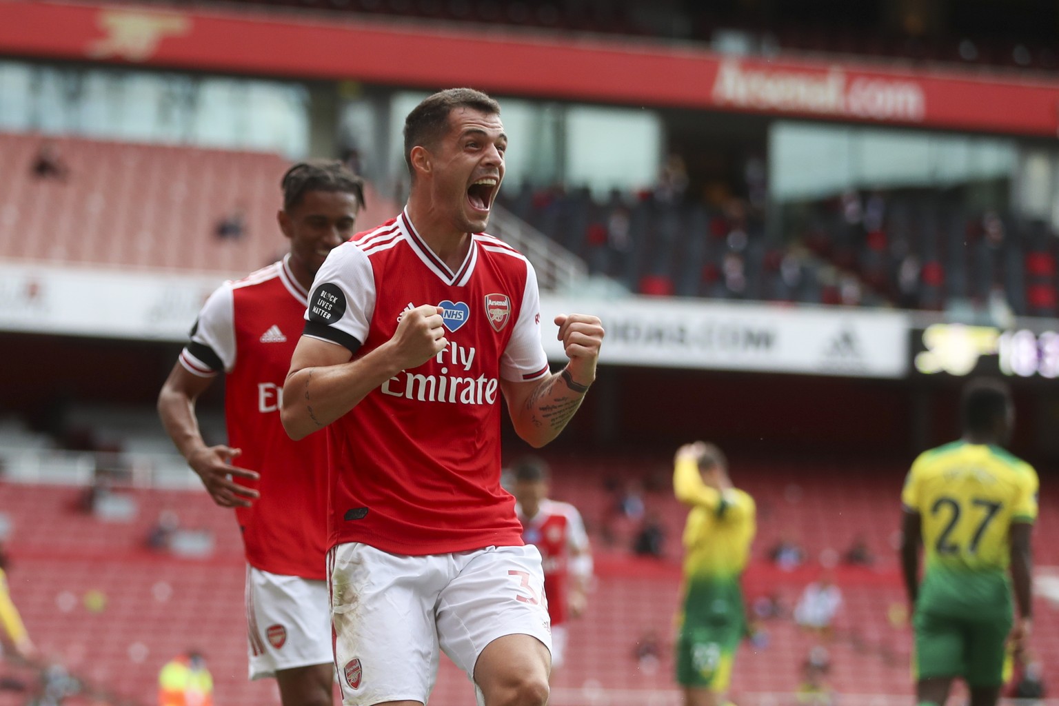 epa08521239 Granit Xhaka (R) of Arsenal celebrates after scoring the 2-0 lead during the English Premier League soccer match between Arsenal FC and Norwich City in London, Britain, 01 July 2020. EPA/M ...