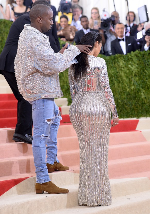 Kanye West, left, fixes Kim Kardashian West&#039;s hair as they arrive at The Metropolitan Museum of Art Costume Institute Benefit Gala, celebrating the opening of &quot;Manus x Machina: Fashion in an ...