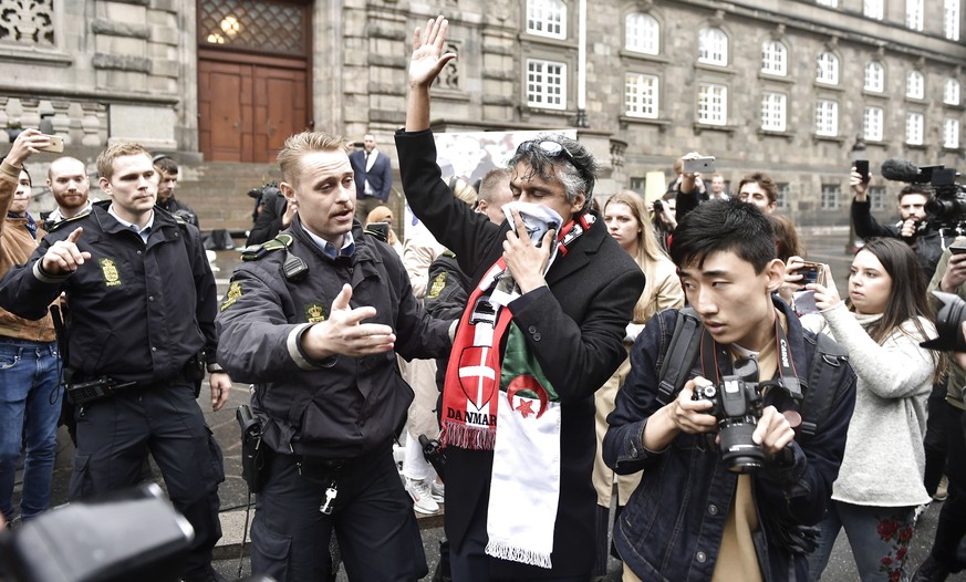 epa07012630 French-Algerian businessman, Rachid Nekkaz (C), is asked by to police officers to step down from the main entrance in front of the Danish Parliament Christiansborg in Copenhagen, Denmark,  ...