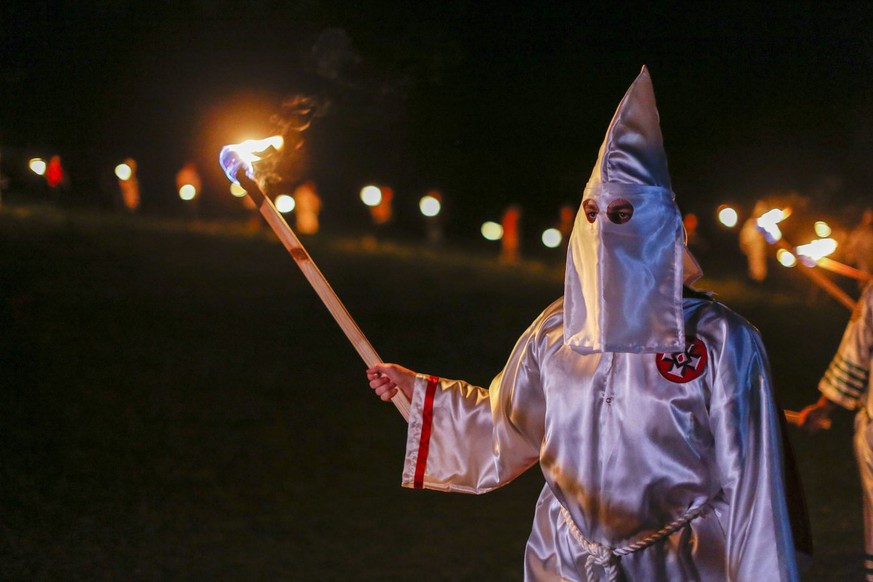 epa05275310 A picture made available on 24 April 2016 shows Pro-white rights organizations the neo-nazi National Socialist Movement and Ku Klux Klan groups participate in a cross and swastika burning  ...
