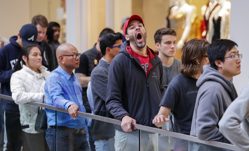 epa06306395 A man yawns with other customers while waiting in line to purchase the newly released iPhone X at an Apple Store inside the Perimeter Mall in Atlanta, Georgia, USA, 03 November 2017. Apple ...