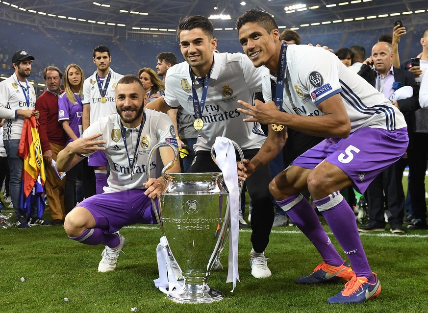 epa06009981 Real Madrid players Karim Benzema (L), Enzo Zidane and Raphael Varane (R) celebrate with the trophy after the UEFA Champions League final between Juventus FC and Real Madrid at the Nationa ...