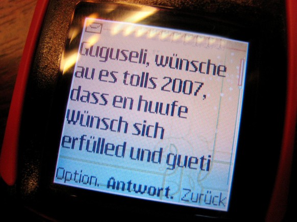 Neujahrswuensche auf einem Display eines Mobiltelefons werden in der Nacht vom 31. Dezember 2006 auf den 1. Januar 2007 per SMS verschickt. In der Schweiz sind an Silvester bis Mitternacht ueber 47 Mi ...