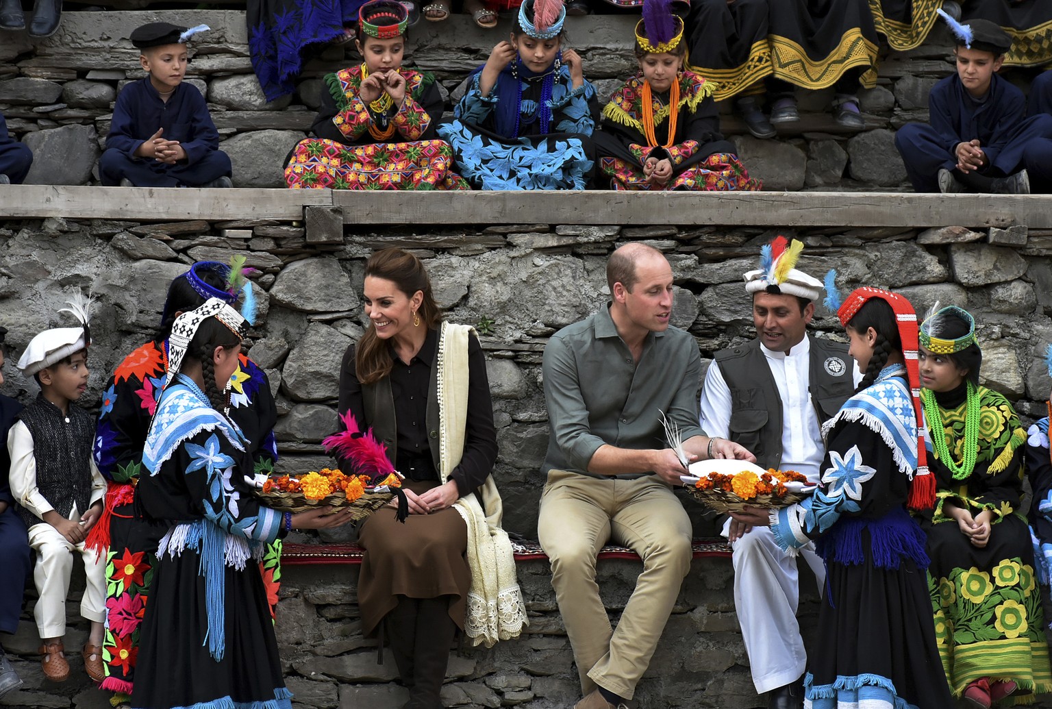 In this photo released by Press Information Department, Members of Kalash community greet Britain&#039;s Prince William, center, and his wife Kate to presents and traditional caps during their visit t ...