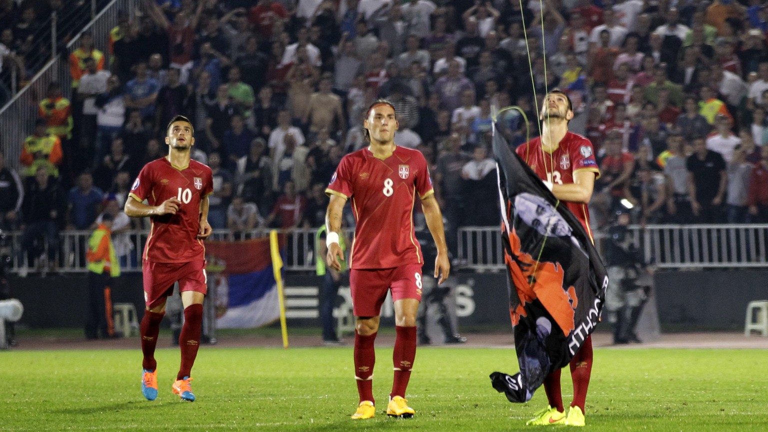 FILE - In this file photo dated Tuesday, Oct. 14, 2014, Serbia&#039;s Stefan Mitrovic grabs a banner containing the Albanian flag attached to a drone flying above the pitch during the Euro 2016 Group  ...