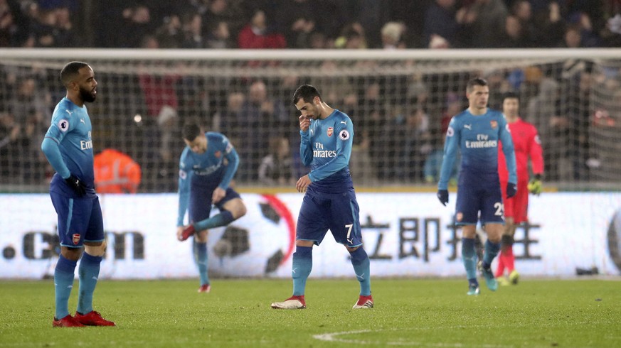 Arsenal&#039;s Henrikh Mkhitaryan, center, looks dejected after Arsenal concede their third goal of the game during the English Premier League soccer match between Swansea City and Arsenal at the Libe ...