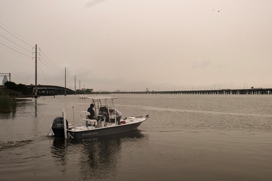 epa08510708 A boat heads out to Mobile Bay as Interstate 10 is covered in haze from the arrival of the Sahara Dust Cloud, in Mobile, Alabama, USA, 26 June 2020. The large cloud of dust originated in A ...