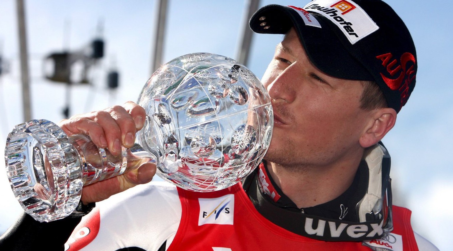epa01283381 Austria&#039;s Hannes Reichelt kisses the crystal globe trophy after winning the men&#039;s Super-G World Cup on the podium of the Alpine Skiing World Cup Finals in Bormio, northern Italy, ...