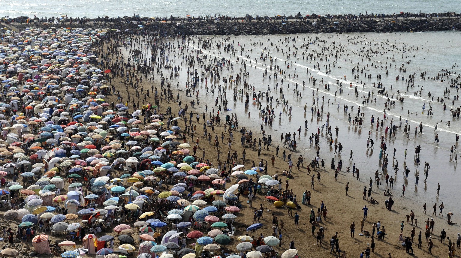 epa06105951 A crowd of people pack the beach in Rabat, Morocco, July 23, 2017. Moroccans and tourists took advantage of beautiful summer weather to enjoy the beach. Morocco welcomed about 3 million to ...