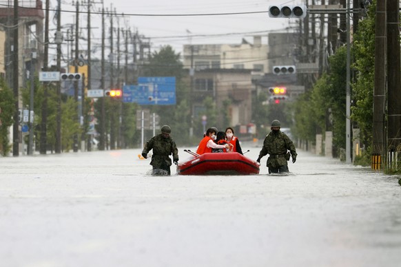 Japan Self Defense Force members rescue residents on a rubber boat on a flooded road hit by heavy rain in Omuta, Fukuoka prefecture, southern Japan Tuesday, July 7, 2020. Rescue operations continued a ...