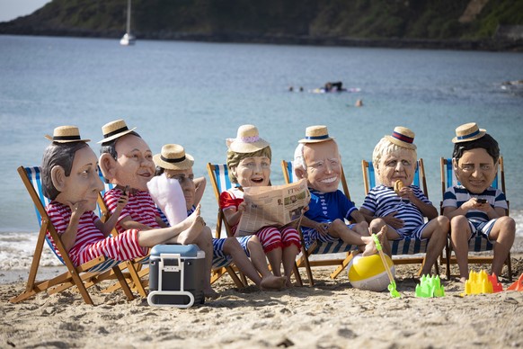 epa09264552 Oxfam campaigners wearing costumes depicting G7 leaders pose for photographers on Swanpool Beach near Falmouth, Cornwall, Britain 12 June 2021. Britain is hosting the G7 summit in Cornwall ...