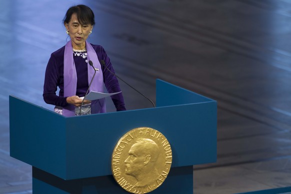 FILE- In this Saturday, June 16, 2012 file photo, Myanmar opposition leader Aung San Suu Kyi, holds her speech during the Peace Nobel Prize lecture at the city hall in Oslo as she formally accepts the ...