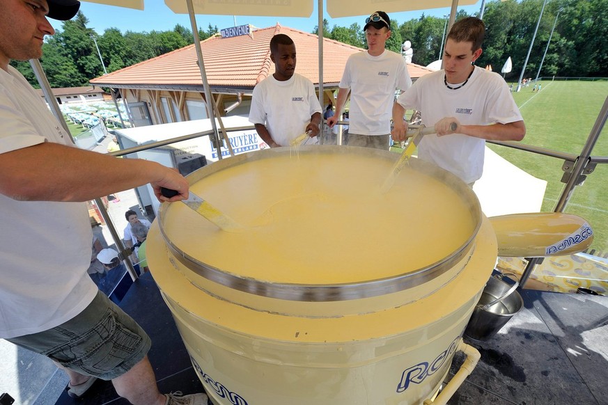 Des personnes preparent la plus grande fondue au fromage du monde, 1336, 6 kg au total, ce samedi 26 juin 2010 a Semsales, dans le canton de Fribourg. (KEYSTONE/Dominic Favre)