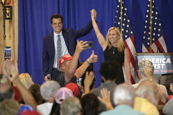 Rep. Matt Gaetz, R-Fla., left, and Rep. Marjorie Taylor Greene, R-Ga., raise their arms after addressing attendees of a rally, Friday, May 7, 2021, in The Villages, Fla. (AP Photo/Phelan M. Ebenhack)