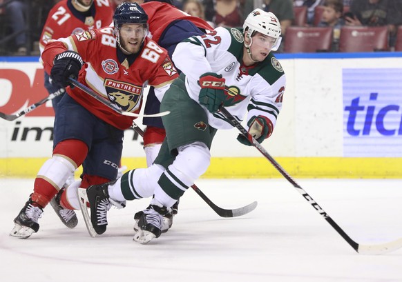 Florida Panthers left wing Mike Hoffman (68) and Minnesota Wild left wing Kevin Fiala (22) battle for the puck during the first period of an NHL hockey game, Friday, March 8, 2019 in Sunrise, Fla. (AP ...