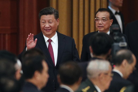 Chinese President Xi Jinping, left, waves as he arrives with his Premier Li Keqiang to a dinner marking the 69th anniversary of the founding of the People&#039;s Republic of China at the Great Hall of ...