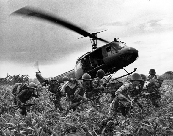 FILE- In this June 1970 file photo, taken by Associated Press photographer Huynh Cong &quot;Nick&quot; Ut, south Vietnamese Marines rush to the point where descending U.S. Army helicopter will pick th ...