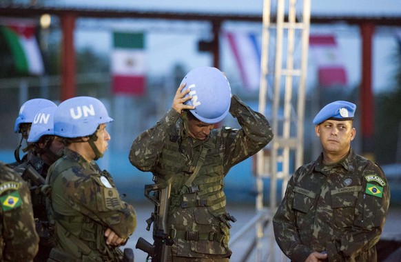 A United Nations peacekeeper from Brazil fixes his helmet before the end of operations ceremony for the United Nations Stabilization Mission in Port-au-Prince, Haiti, Thursday, Oct. 5, 2017. The U.N.  ...