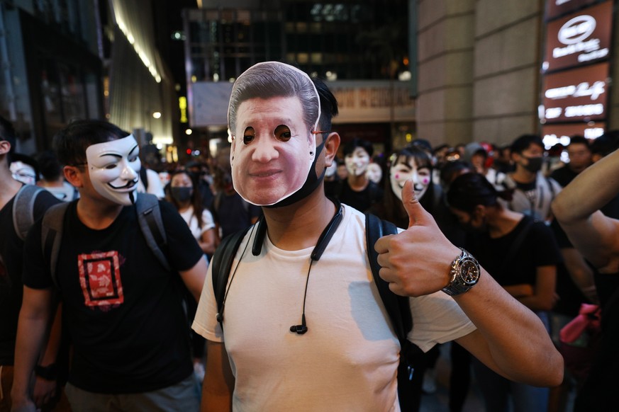 epa07962563 A protester wearing a mask of Chinese President Xi Jinping gestures during a Halloween rally in Lan Kwai Fong, a bar district in Central in Hong Kong, China, 31 October 2019. Hong Kong has ...