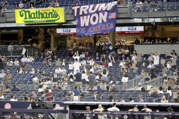 epa09232233 Two supporters of former US President Donald Trump display a Trump Won Save America Banner during the fourth inning of a double header game against the Toronto Blue Jays during their MLB g ...