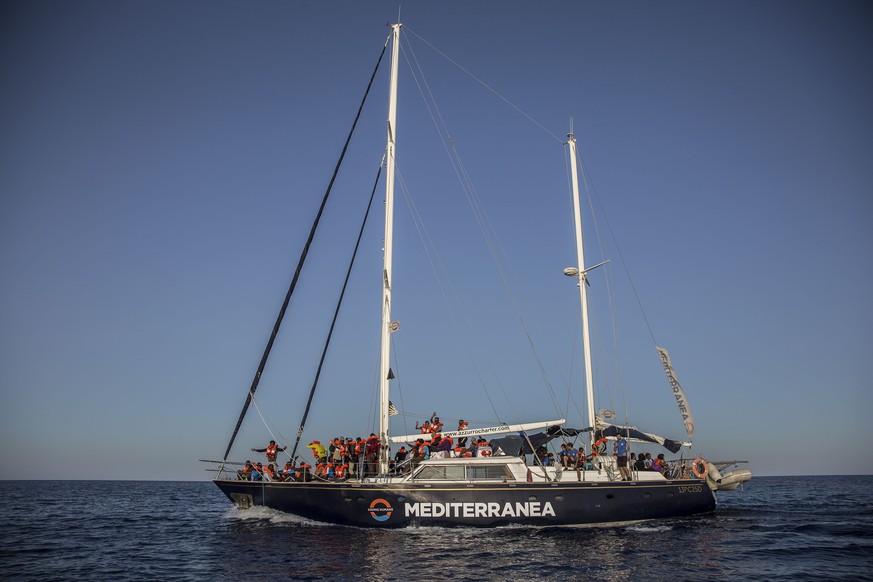 Migrants rest on a Mediterranea Saving Humans NGO boat, as they sail off Italy&#039;s southernmost island of Lampedusa, just outside Italian territorial waters, on Thursday, July 4, 2019. An Italian h ...