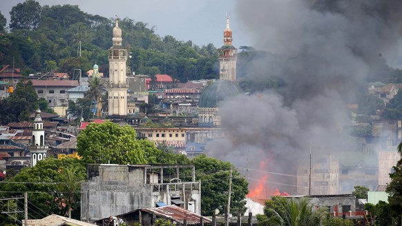 A fire rages at houses following airstrikes by Philippine Air Force in Marawi, southern Philippines, Saturday, May 27, 2017. Philippine military jets fired rockets at militant positions Saturday as so ...