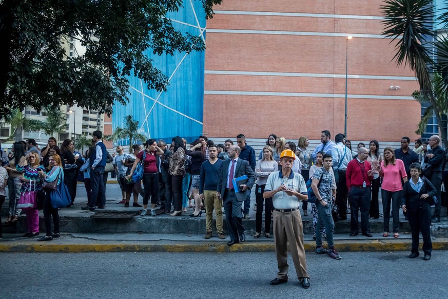 epa06963311 A group of people remains in the street after an earthquake was registered, in Caracas, Venezuela, 21 August 2018. Venezuelans were shaken today by a strong earthquake of magnitude 6.3 wit ...