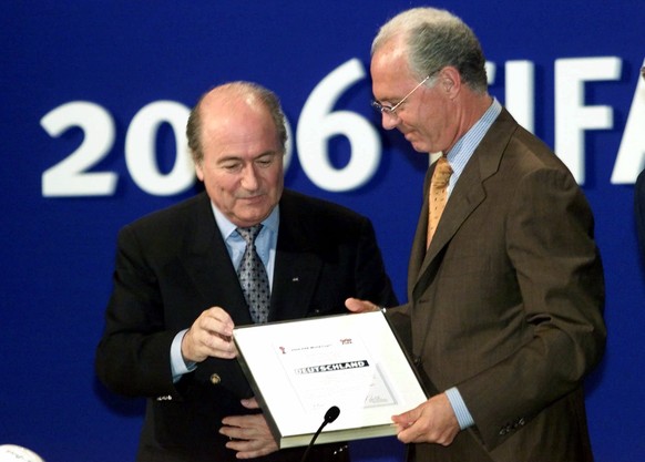 FILE - In this July 6, 2000 file picture FIFA president Joseph Blatter, left, hands over the World Cup documents to Franz Beckenbauer of the German delegation in Zurich, Switzerland, after soccer&#039 ...
