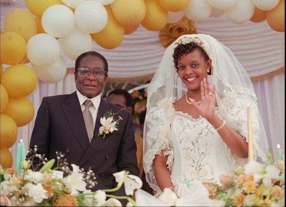 FILE - In this Saturday, Aug. 17, 1996, file photo, Grace Marufu, the new bride of Zimbabwean President Robert Mugabe, right, waves at guests after their wedding ceremony at the Kutama catholic missio ...
