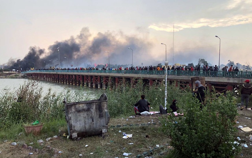 epa08030657 Smoke clouds rise from a military base which was reportedly stormed by Iraqi protesters during clashes with security forces in Nasiriyah city, some 370km southeast of Baghdad, Iraq, 28 Nov ...