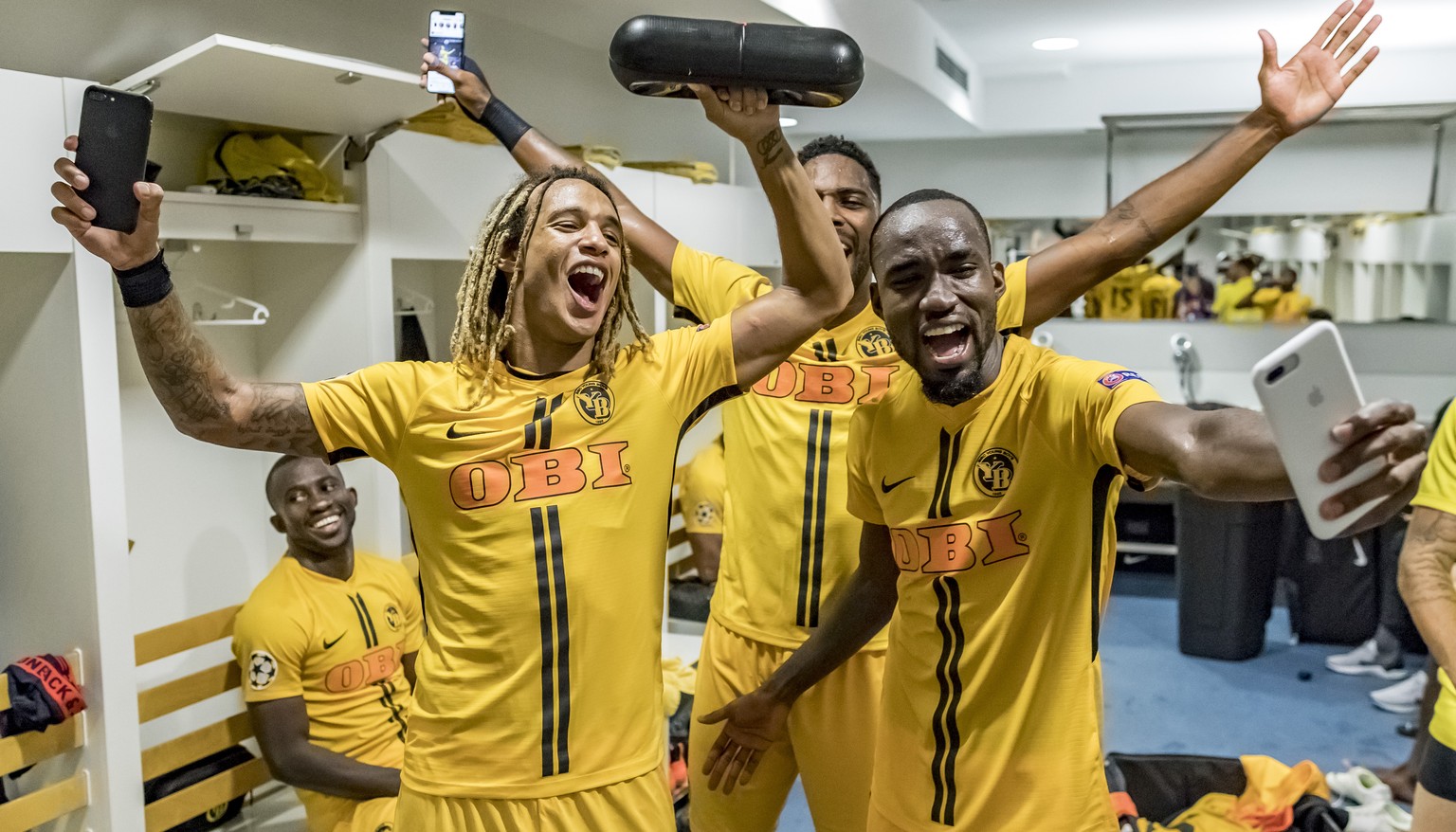 YB&#039;s Kevin Mbabu, Ulisses Garcia and Nicolas Moumi Ngamaleu, from left, celebrate in the locker room after qualifying for the group stage of the Champions League, after the UEFA Champions League  ...