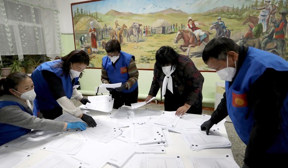 epa08720489 Members of Kyrgyz local election commission count ballots after the closure of a polling station in the village of Gornaya Maevka, 30km from Bishkek, Kyrgyzstan, 04 October 2020. EPA/IGOR  ...