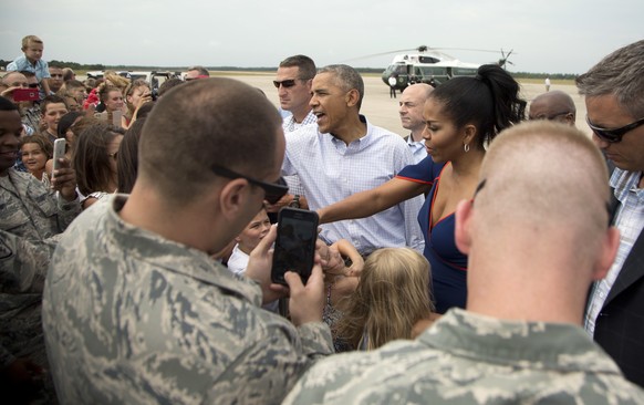 President Barack Obama and first lady Michelle Obama greet members of the military and their family as they arrive at Air Station Cape Cod, in Mass., Saturday, Aug. 6, 2016. The president and his fami ...
