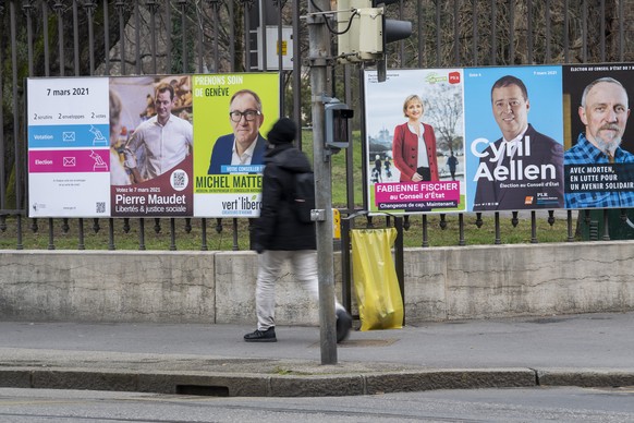 Une personne passe devant les affiches des candidats pour l&#039;election complementaire d&#039;un membre du Conseil d&#039;Etat, avec les portraits sur les affiches de Pierre Maudet, du parti Liberte ...