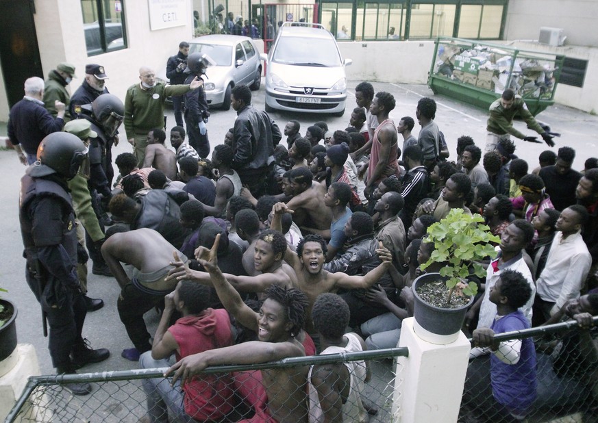 epa05798717 Dozens of migrants celebrate after they managed to cross and jump the fences at the Tarajal border in Ceuta, Spain, 17 February 2017. Some 500 Sub-Saharan migrants entered the Spanish encl ...