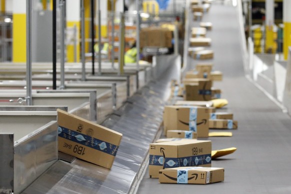 FILE - In this Dec. 17, 2019, file photo, Amazon packages move along a conveyor at an Amazon warehouse facility in Goodyear, Ariz. Amazon