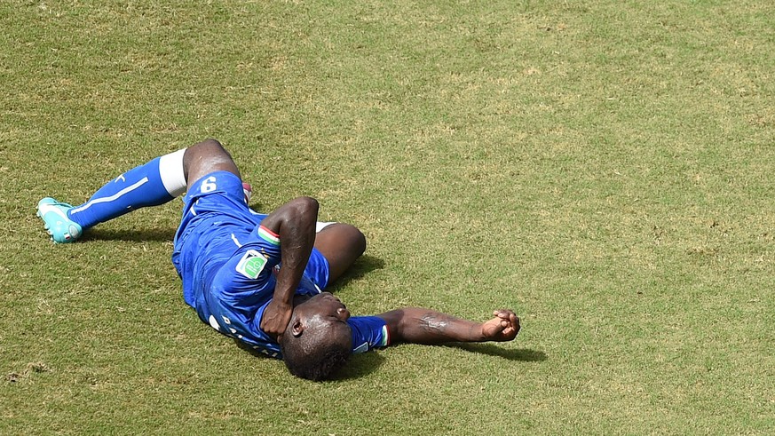 epa04277881 Mario Balotelli of Italy lies on the pitch during the FIFA World Cup 2014 group D preliminary round match between Italy and Uruguay at the Estadio Arena das Dunas in Natal, Brazil, 24 June ...